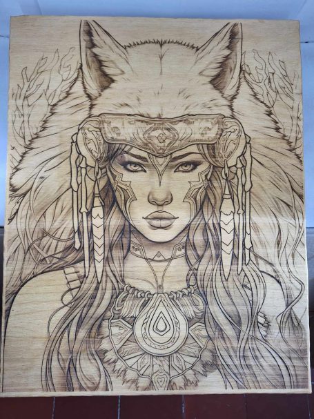 Portrait d'une femme avec des éléments de loup et des bijoux ethniques gravés sur bois.